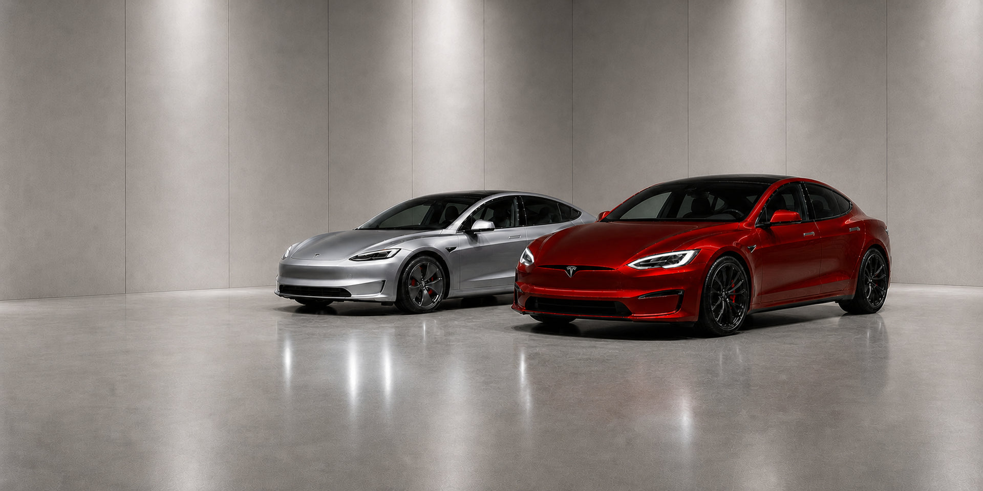Tummanpunainen Tesla Model S ja harmaa Tesla Model 3 Highland vaaleassa studiossa